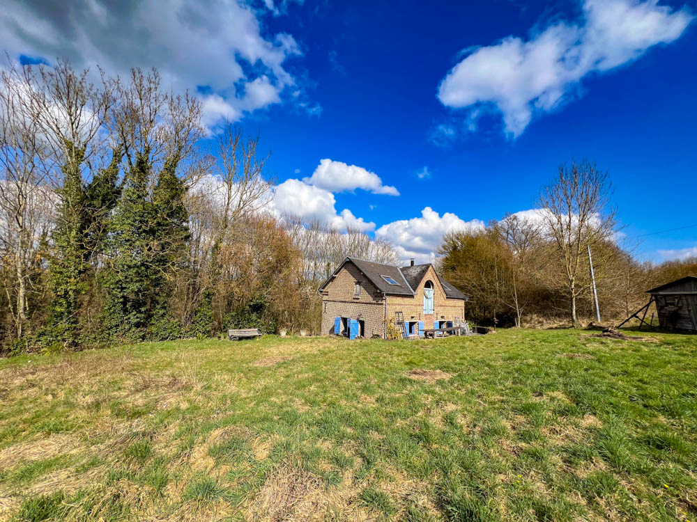 Un joli pressoir rénové aux volets bleus.