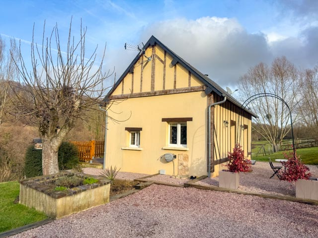 Une petite maison avec pâturage dans une vallée.